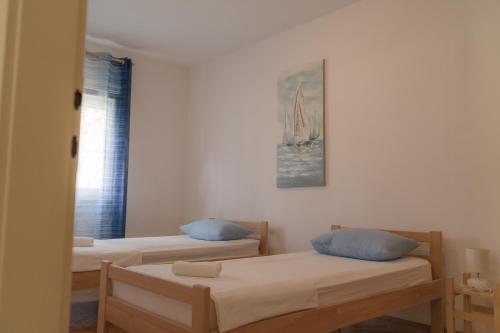 Cette chambre comprend 2 lits et une fenêtre. dans l'établissement Apartment Gloria, à Kaštela