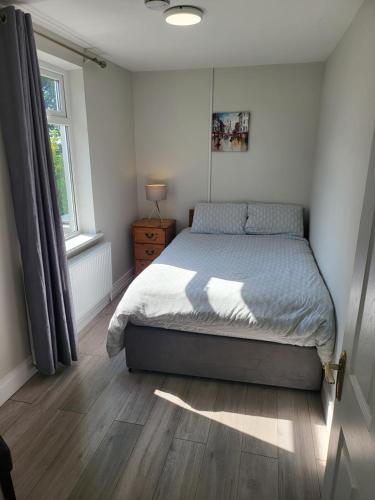 a bedroom with a bed and a window at Peaceful Farm Cottage in Menlough near Mountbellew, Ballinasloe, Athlone & Galway in Galway