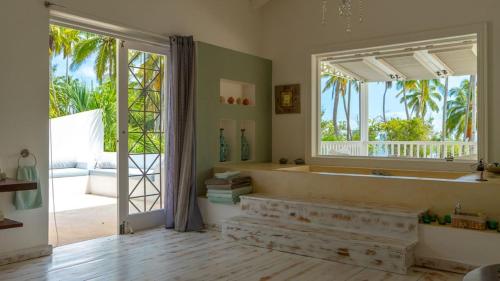a bathroom with a tub and a large window at Villa Azulsalado - Frente a la playa in Las Terrenas