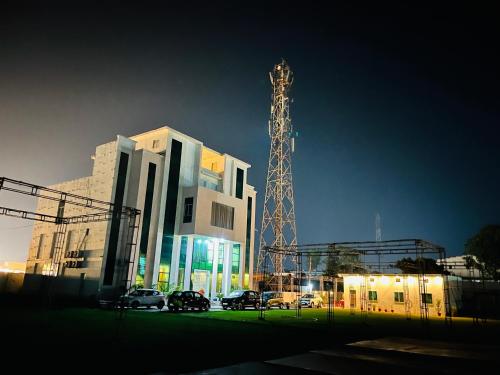 a large building with a tower in front of it at Hotel MK Lawn in Bareilly