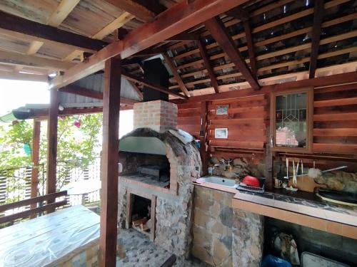 an outdoor kitchen with a stone oven in a house at Drinski odmor ,,Mima,, 1 in Perućac
