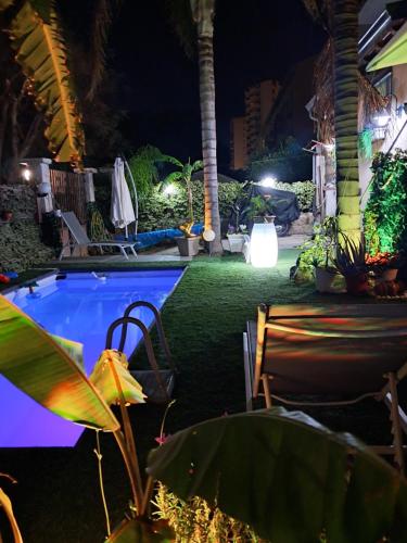 a swimming pool at night with chairs and plants at Casa Le Rose in Palermo