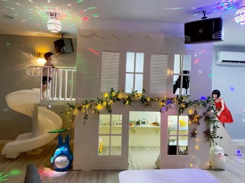 a room with a toy house with lights and people at PulauKetam HuaHeeHomes 吉胆岛欢喜亲子民宿 in Bagan Teochew