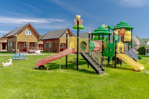 a park with a playground with slides and play equipment at Domki Morena - Rodzinne Domki Blisko Plaży in Karwia