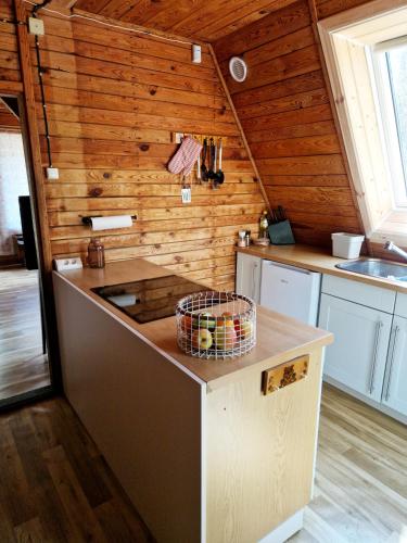 a kitchen with wooden walls and a counter top at Leśna Chatka in Wola Polska