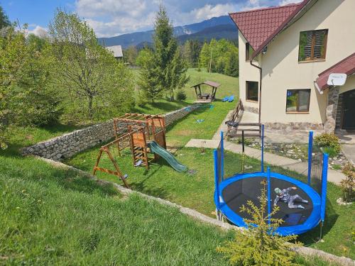 een tuin met een speeltuin in het gras bij La Kaifas in Fundata