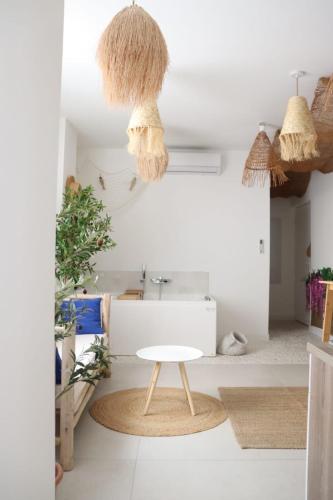 une pièce blanche avec une table et quelques paniers dans l'établissement Loveroom Mykonos avec balnéothérapie, à Toulon