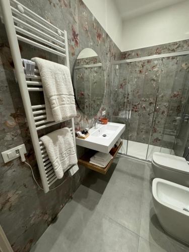 a bathroom with a sink and a toilet and a mirror at Vesuvius Pompeii in Pompei