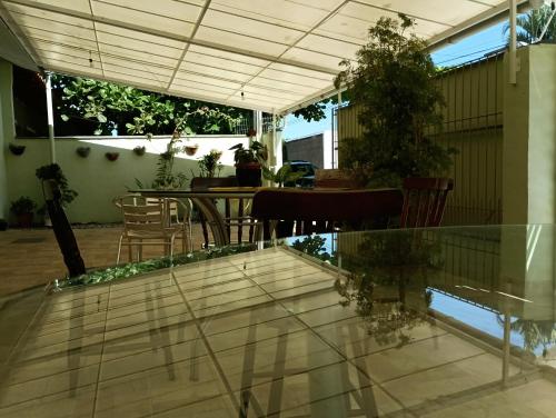 un patio con tavolo, sedie e pavimento in vetro di Pousada Executiva SolRiso Aeroporto Florianópolis a Florianópolis