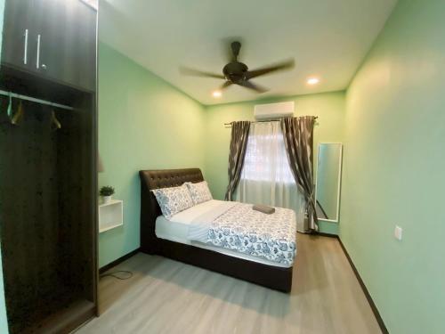 a bedroom with a bed and a ceiling fan at PulauKetam HuaHeeHomes 吉胆岛欢喜亲子民宿 in Bagan Teochew