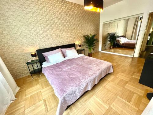 a bedroom with a large bed with a purple comforter at Luxury Apartment in Old Town in Prague
