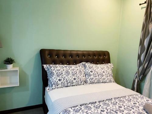 a bedroom with a bed with a brown headboard at PulauKetam HuaHeeHomes 吉胆岛欢喜亲子民宿 in Bagan Teochew