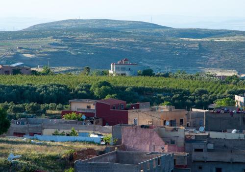 une petite ville avec une maison sur une colline dans l'établissement Vila Haja - Beautiful Farmhouse with a Private Pool!, à Imouzzer du Kandar