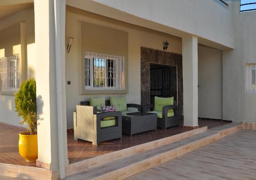 a patio with couches and chairs on a porch at Vila Haja - Beautiful Farmhouse with a Private Pool! in Imouzzer Kandar