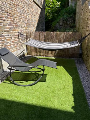 a hammock and a chair in a yard at Appartement Dio in Dinant
