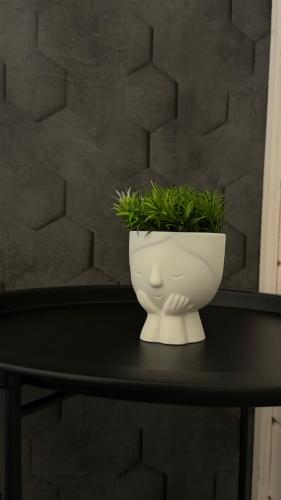 a white vase on a table with a plant in it at Weekend house in Verkhovyna