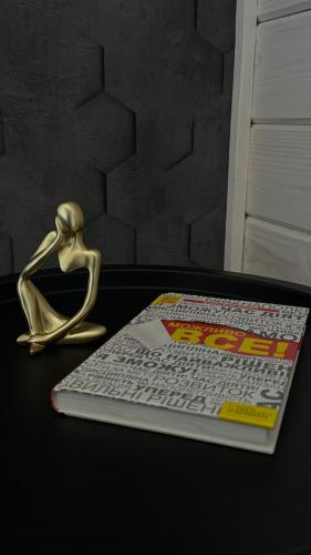 a gold statue next to a magazine on a table at Weekend house in Verkhovyna