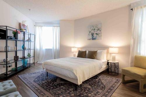 ein Schlafzimmer mit einem großen Bett und einem Stuhl in der Unterkunft Tulip - 2 bedroom apartment in West Hollywood in Los Angeles
