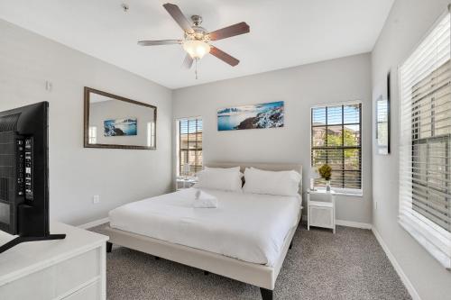 a white bedroom with a bed and a ceiling fan at Luxury 3bd, 2bath, universal studios in Orlando
