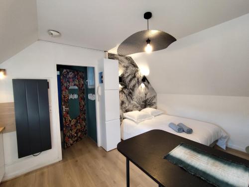 a bedroom with a bed and a table and a window at LE ARA - Gare - centre ville - By Nid'Ouest in Quimper