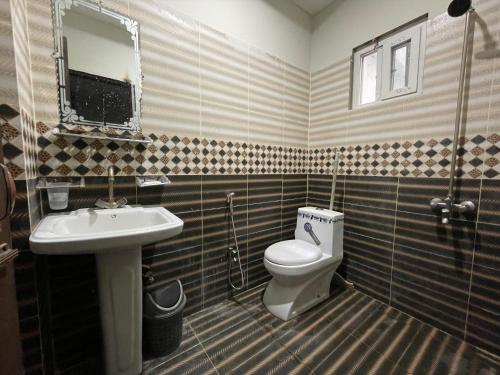 La salle de bains est pourvue de toilettes et d'un lavabo. dans l'établissement Own It Apartment Brown, à Islamabad