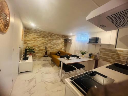 a kitchen and a living room with a couch at Appartement indépendant chez l'habitant in Rosny-sur-Seine