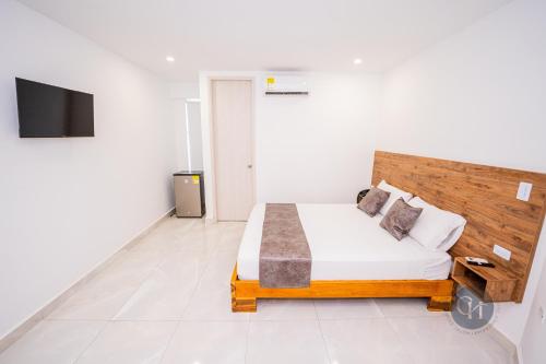 ein Schlafzimmer mit einem Bett und einem TV in der Unterkunft Hotel Chayrama in Santa Marta