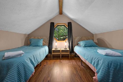 Zimmer im Dachgeschoss mit 2 Betten und einem Fenster in der Unterkunft Fall Wonders - Dollywood at 2 min & Heated Pool in Sevierville