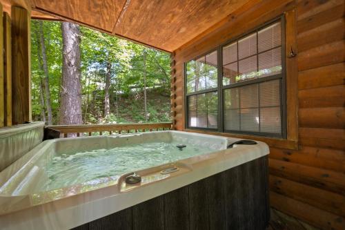 eine große Badewanne in einem Raum mit Fenster in der Unterkunft Fall Wonders - Dollywood at 2 min & Heated Pool in Sevierville