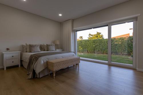 a bedroom with a bed and a large window at Casa da Cruz Alta in Seia