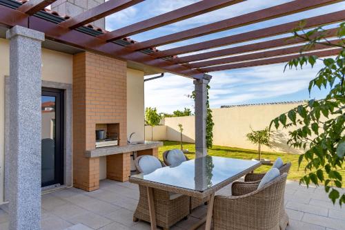 a patio with a table and wicker chairs at Casa da Cruz Alta in Seia