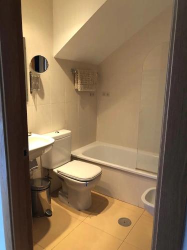 a bathroom with a toilet and a sink and a tub at Naranjos Condado in Alhama de Murcia