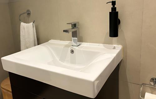 a white sink with a faucet in a bathroom at Meerendahl Luxury Apartments at Heritage Square in Durbanville