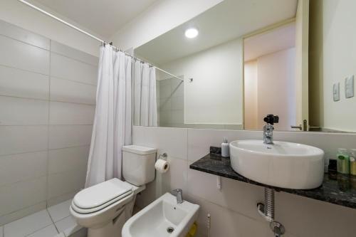 een witte badkamer met een toilet en een wastafel bij Loft en Güemes in Cordoba