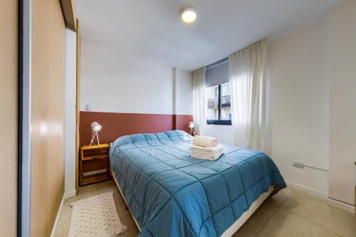 een slaapkamer met een blauw bed en een raam bij Loft en Güemes in Cordoba