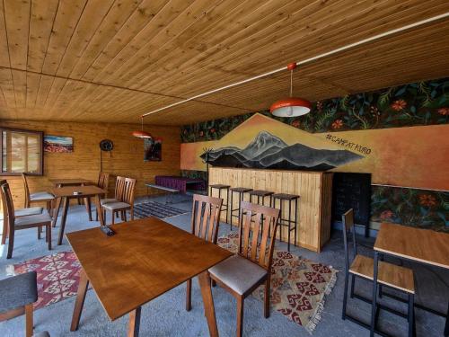 a dining room with tables and chairs and a fireplace at Kuro Kazbegi • ყურო ყაზბეგი in Stepantsminda
