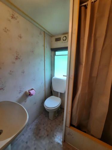 une petite salle de bain avec toilettes et lavabo dans l'établissement Mobilhome vintage 