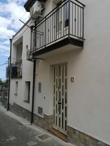 a white building with a balcony and a door at Donna Concetta in Patti