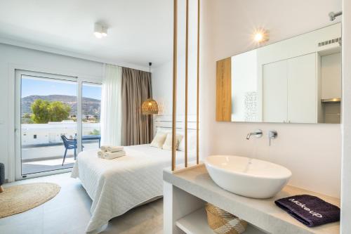 ein Hotelzimmer mit einem Bett und einem Waschbecken in der Unterkunft Alkithea luxury suites in Karpathos