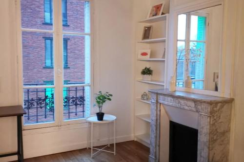- un salon avec une cheminée et 2 fenêtres dans l'établissement Authentic Parisien Suite -Paris historique/Metro, à Saint-Ouen