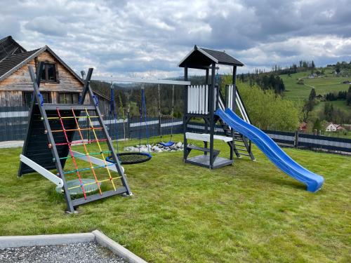 a playground with two swings and a slide at Willa Jaworzynka 1103 K Istebnej in Jaworzynka