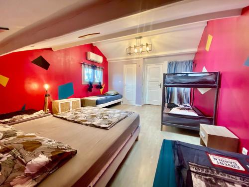 - une chambre avec des murs roses et un grand lit dans l'établissement Villa - Marseille, à Marseille