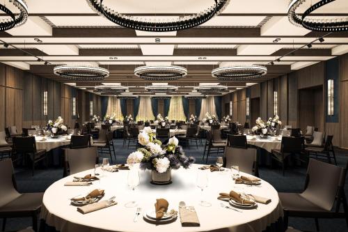a large banquet hall with tables and chairs at Flow and Co. Qingdao, Autograph Collection in Qingdao