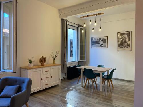 a living room with a dining room table and chairs at Appartement coquet dans le centre de Mèze in Mèze