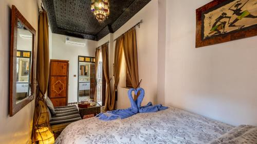 a bedroom with a bed with a blue ribbon at Dar Najat in Marrakech