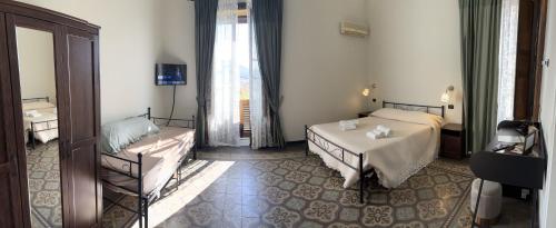 a hotel room with two beds and a mirror at Domus Divina in Cefalù