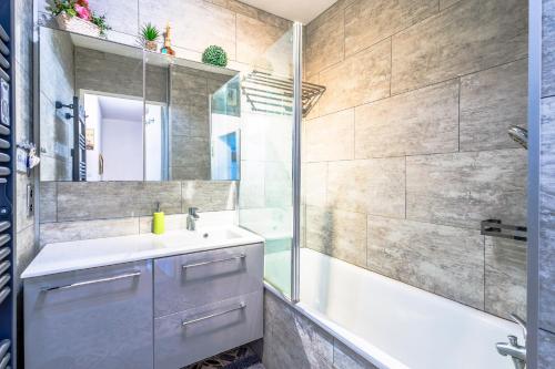 uma casa de banho com uma banheira, um lavatório e um chuveiro em Sweet Dreams em Honfleur