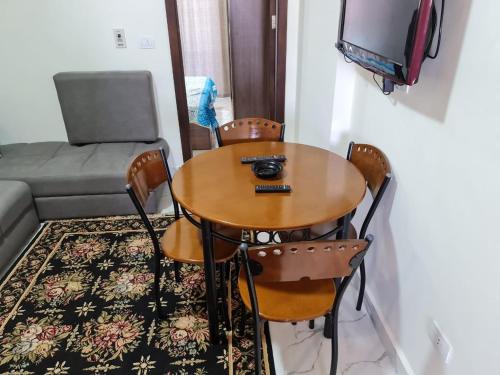 a room with a table and chairs and a television at جولف بورتو مارينا in El Alamein