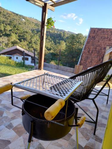a bbq grill with a table on top of it at Casas boa vista in Campos do Jordão