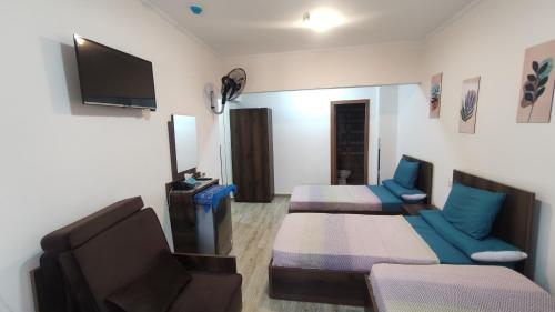 Habitación con cama, sofá y TV. en فندق أجياد Agyad Hotel, en Asiut